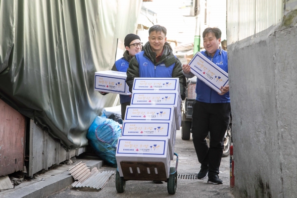 5일 삼성전자 임직원들이 서울 동대문구에 위치한 쪽방을 찾아 거주하는 어르신들에게 전달할 생필품 세트를 나르고 있다.