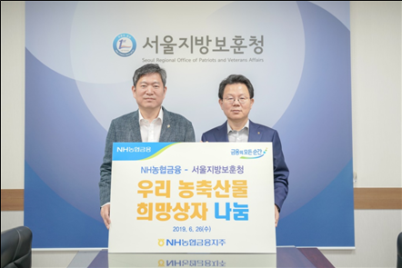 김광수(오른쪽) NH농협금융지주 회장이 오진영 서울지방보훈청장에게 위문품을 전달하고 있다. 사진=농협금융.