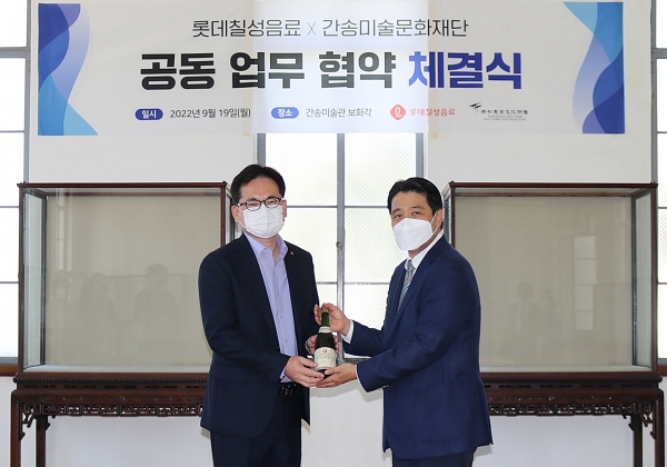 지난 19일 진행된 ‘한국 미술 산업의 성장과 발전을 위한 업무 협약’식 중 전인건 관장(오른쪽)이 박윤기 대표이사(왼쪽)에게 개인 보관 중이었던 1979년산 마주앙을 전달하고 있다. 사진=롯데칠성음료